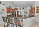 Modern kitchen featuring a breakfast bar, dark cabinets, and stainless steel appliances at 9208 Brindlewood Dr, Odessa, FL 33556