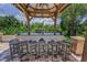 Outdoor kitchen and bar with seating in a covered gazebo, ideal for entertaining guests at 9208 Brindlewood Dr, Odessa, FL 33556
