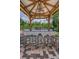This outdoor kitchen features a granite countertop, stainless steel grill, and barstool seating under a covered structure at 9208 Brindlewood Dr, Odessa, FL 33556