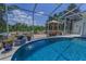 Serene pool area with a charming water feature, gazebo, and lush landscaping for ultimate relaxation at 9208 Brindlewood Dr, Odessa, FL 33556