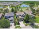 Stunning aerial view of the home, showcasing the neighborhood, nearby pond, mature trees, and well-maintained landscaping at 9317 Bella Vita Cir, Land O Lakes, FL 34637