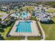 Aerial view showcasing community amenities: swimming pools, water park, clubhouse, and surrounding neighborhood at 9317 Bella Vita Cir, Land O Lakes, FL 34637