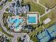 Aerial perspective of community pools, clubhouse, tennis courts, beach volleyball, and meticulously kept grounds at 9317 Bella Vita Cir, Land O Lakes, FL 34637