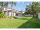 Spacious backyard featuring lush green lawn, mature landscaping, and a paved patio, perfect for outdoor entertaining at 9317 Bella Vita Cir, Land O Lakes, FL 34637