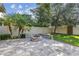 Backyard featuring a brick firepit and palm trees at 9317 Bella Vita Cir, Land O Lakes, FL 34637
