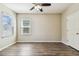 Bedroom with wood-look flooring, a ceiling fan, and windows for natural light at 9317 Bella Vita Cir, Land O Lakes, FL 34637