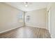 Bright bedroom with wood-look floors, two windows, and a ceiling fan at 9317 Bella Vita Cir, Land O Lakes, FL 34637
