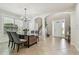 Open-concept dining room with a stylish table, tile floors, and a view of the front entry at 9317 Bella Vita Cir, Land O Lakes, FL 34637