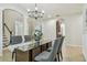 Elegant dining room featuring a glass-top table, a modern chandelier, and tile flooring at 9317 Bella Vita Cir, Land O Lakes, FL 34637