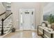 Welcoming foyer with a staircase, tile flooring, and a stylish console table at 9317 Bella Vita Cir, Land O Lakes, FL 34637