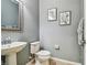 Cozy half bathroom with a pedestal sink, a toilet, and decorative wall art at 9317 Bella Vita Cir, Land O Lakes, FL 34637