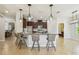 Modern kitchen with a center island, granite countertops, pendant lighting, and dark wood cabinets at 9317 Bella Vita Cir, Land O Lakes, FL 34637