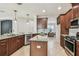 A kitchen with stainless appliances, granite countertops and dark wood cabinets offers a view into the dining area at 9317 Bella Vita Cir, Land O Lakes, FL 34637