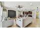 Open-concept living room flows into a kitchen with stainless steel appliances and a breakfast bar at 9317 Bella Vita Cir, Land O Lakes, FL 34637