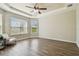 Bright main bedroom features a tray ceiling, large windows, and wood-look flooring at 9317 Bella Vita Cir, Land O Lakes, FL 34637