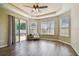 Large main bedroom includes a tray ceiling, wood-look flooring, and sliding glass door to the patio at 9317 Bella Vita Cir, Land O Lakes, FL 34637