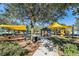 Community playground featuring shade structures, play equipment, picnic tables, and lush landscaping at 9317 Bella Vita Cir, Land O Lakes, FL 34637