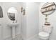 Modern half-bathroom features a stylish pedestal sink, decorative shelves and contemporary fixtures at 9734 Branching Ship Trce, Wesley Chapel, FL 33545