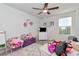 Bright bedroom featuring a ceiling fan, plush rug, and a playful arrangement of toys and decor at 9734 Branching Ship Trce, Wesley Chapel, FL 33545