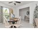 Bright dining area features a wooden table, white chairs, decorative accents, and tiled flooring at 9734 Branching Ship Trce, Wesley Chapel, FL 33545