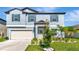 Charming two-story home boasts a manicured lawn and a welcoming front door with decorative wreath at 9734 Branching Ship Trce, Wesley Chapel, FL 33545