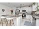 Modern kitchen with granite countertops, white cabinets, stainless steel appliances, and a breakfast bar at 9734 Branching Ship Trce, Wesley Chapel, FL 33545