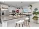 Modern kitchen with granite countertops, white cabinets, stainless steel appliances, and a breakfast bar at 9734 Branching Ship Trce, Wesley Chapel, FL 33545