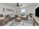 Cozy living room featuring comfortable sofas, ceiling fan and large window that provides natural light at 9734 Branching Ship Trce, Wesley Chapel, FL 33545