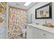 Bright bathroom with a white vanity, patterned shower curtain, and modern fixtures at 9821 113Th St # 201, Seminole, FL 33772