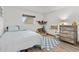 Cozy bedroom with a twin sized bed, wooden dresser, blue accents, and a window providing natural light at 9821 113Th St # 201, Seminole, FL 33772