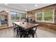 Dining room with a large wooden table, black chairs, and a wall with wooden accents and a metal sun decoration at 9821 113Th St # 201, Seminole, FL 33772
