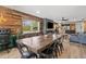 Open-concept dining room featuring a rustic wooden table, modern black chairs, wood wall, fireplace, and kitchen bar at 9821 113Th St # 201, Seminole, FL 33772
