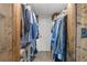 Well-organized walk-in closet with wooden shelves and rods, featuring an assortment of clothing at 9821 113Th St # 201, Seminole, FL 33772