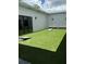Turf backyard with cornhole, seating, and string lights offers a private, outdoor entertainment area at 10098 Banyan Breeze Blvd, Land O Lakes, FL 34638
