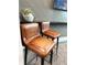 Close-up of two vintage bar stools, complete with brown leather seats and metal frames, adding character to the room at 10098 Banyan Breeze Blvd, Land O Lakes, FL 34638