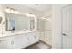 Bathroom featuring double sinks, a glass shower, modern lighting, and tile flooring at 10098 Banyan Breeze Blvd, Land O Lakes, FL 34638