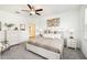 Well-lit bedroom boasts neutral decor, a ceiling fan, carpet, and an ensuite bathroom at 10098 Banyan Breeze Blvd, Land O Lakes, FL 34638