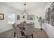Cozy dining room with a round table, four chairs, a decorative chandelier, and stylish wall art at 10098 Banyan Breeze Blvd, Land O Lakes, FL 34638