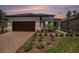 Charming single-story home featuring a brick driveway, two-car garage, and neatly manicured landscaping at 10098 Banyan Breeze Blvd, Land O Lakes, FL 34638