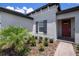 Close up on the home's facade, highlighting its elegant gray exterior, complemented by a palm tree and manicured garden at 10098 Banyan Breeze Blvd, Land O Lakes, FL 34638