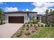 Single-story home boasting a two-car garage, lush landscaping, and an inviting entrance with a rich-toned door at 10098 Banyan Breeze Blvd, Land O Lakes, FL 34638