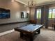 This is a view of the game room with a pool table, seating, and a television at 10098 Banyan Breeze Blvd, Land O Lakes, FL 34638