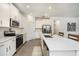 Bright modern kitchen features stainless steel appliances, white cabinetry, and a center island with bar seating at 10098 Banyan Breeze Blvd, Land O Lakes, FL 34638