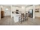Bright kitchen features an island with seating, stainless steel appliances, and wood-look tile flooring at 10098 Banyan Breeze Blvd, Land O Lakes, FL 34638