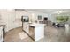 Open-concept kitchen with island seating flows into the living room overlooking the backyard pond at 10098 Banyan Breeze Blvd, Land O Lakes, FL 34638
