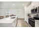 Bright kitchen featuring stainless steel appliances, a large island with a sink, and wood-style flooring at 10098 Banyan Breeze Blvd, Land O Lakes, FL 34638
