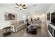 Bright living room features neutral decor, wood-look tile flooring and an open layout to the kitchen at 10098 Banyan Breeze Blvd, Land O Lakes, FL 34638