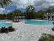 This is a view of the large community pool with sun loungers and palm trees at 10098 Banyan Breeze Blvd, Land O Lakes, FL 34638