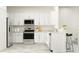 An open kitchen features white cabinets, stainless appliances, and a breakfast bar with seating at 10225 Trumpet Honeysuckle Way, San Antonio, FL 33576