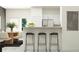 Bright kitchen features a granite countertop bar with modern black stools and stainless steel appliances at 10225 Trumpet Honeysuckle Way, San Antonio, FL 33576